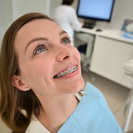 Adult Woman With Braces Smiling In Exam Chair