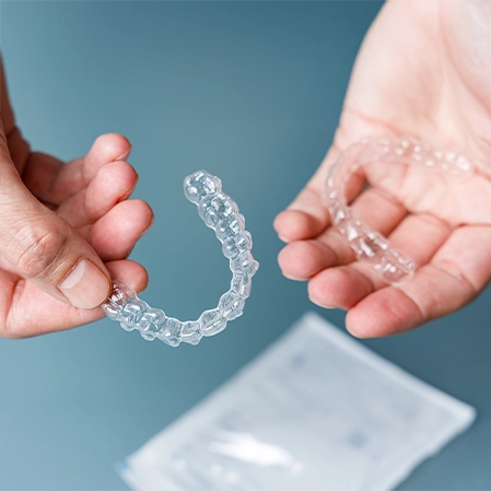Hands Holding A Set Of Invisalign Aligners